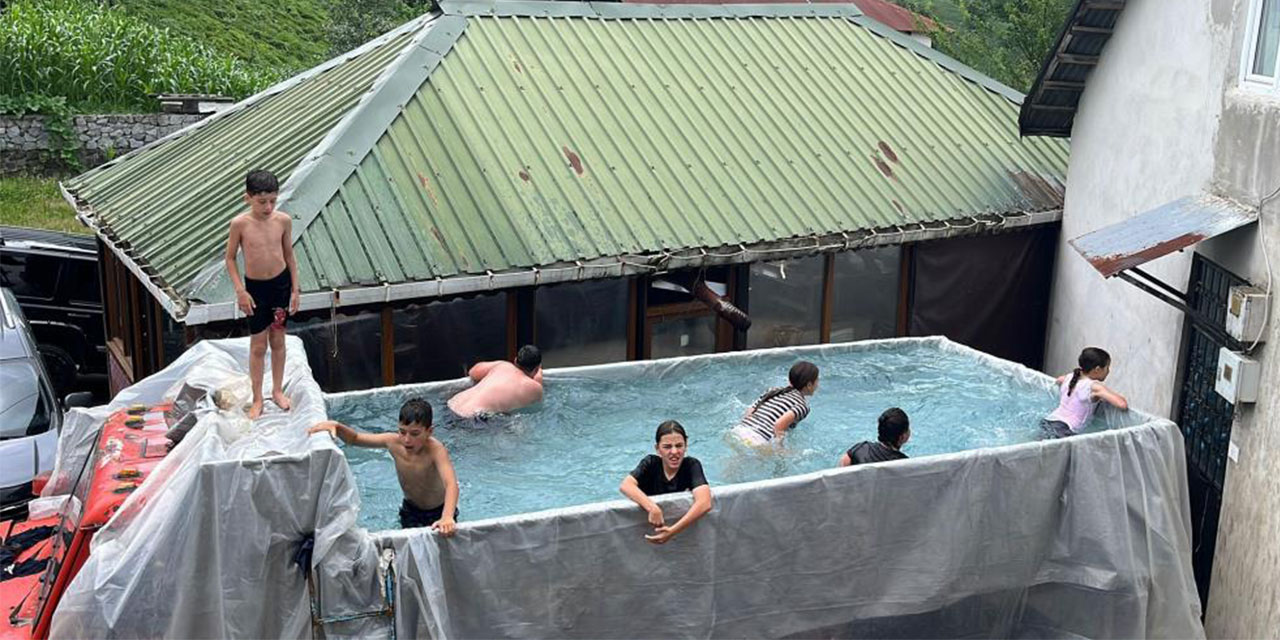 Rize'de sıcaktan bunalan çocuklar için kamyonun kasasını su ile doldurdu